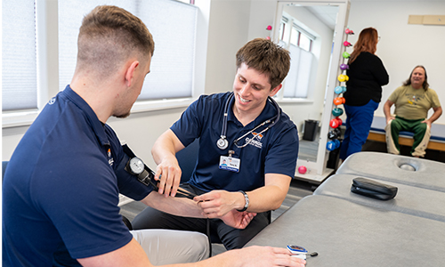 Man practicing taking vitals on a patients.